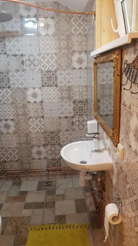 W łazience znajduje się umywalka i lustro. w obiekcie namelis nr 2 Adelės sodyba w mieście Muižė