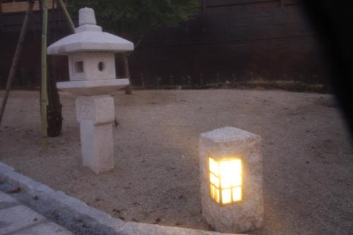 a lantern with a light on it next to a bird house at Ryokan Shinsen in Takachiho