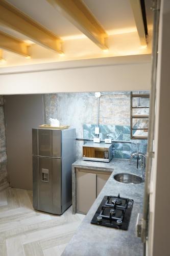 a kitchen with a stainless steel refrigerator and a sink at Zentrico Boutique in Pereira