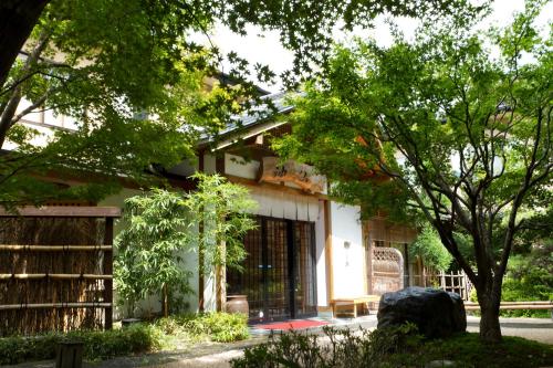 a white building with trees in front of it at Ryokan Shinsen in Takachiho