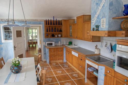 a kitchen with wooden cabinets and a table in it at Gutshof Bartl 2 in Klagenfurt