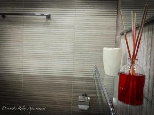 a vase with sticks in it on a bathroom counter at Dream&Relax Apartament Cazare Lupeni-Straja in Lupeni