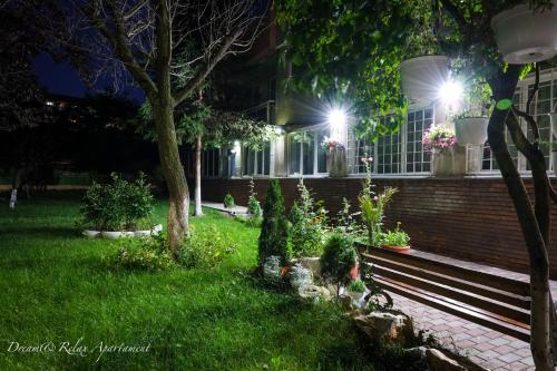 a park bench in front of a house at night at Dream&Relax Apartament Cazare Lupeni-Straja in Lupeni