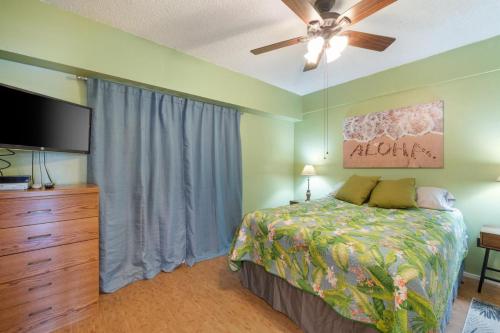 Un dormitorio con una cama y un televisor de pantalla plana. en Kona Plaza#217, en Kailua-Kona