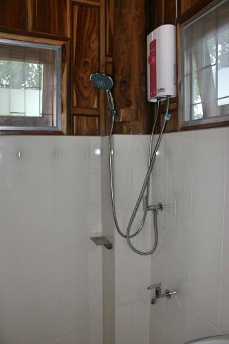 a shower in a bathroom with a shower head at Sichang My home in Ko Si Chang