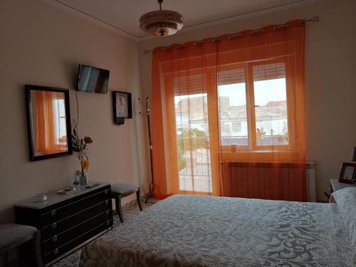 sypialnia z łóżkiem, komodą i oknem w obiekcie Alojamiento Rural w mieście Tobarra