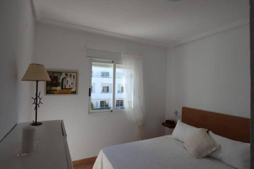biała sypialnia z łóżkiem i oknem w obiekcie Apartamento-Solárium playa Marina de la Torre w mieście Mojácar