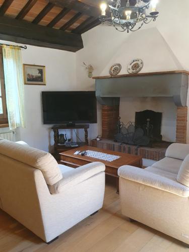 sala de estar con 2 sillas y chimenea en Casa Giogo, en Arezzo