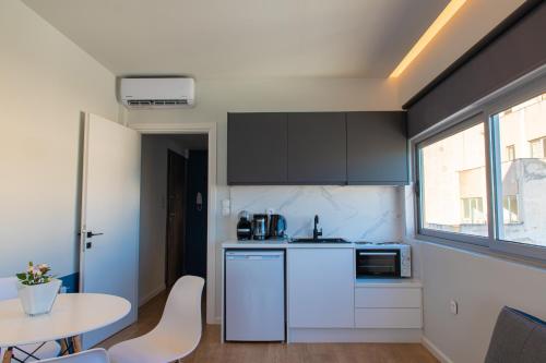 a kitchen with white cabinets and a table and a window at Central Marine Flat in Volos