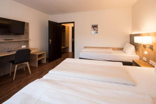 a hotel room with two beds and a desk at 2Places Side in Lörrach