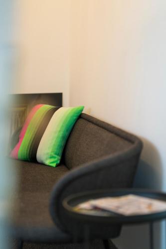 a couch with a colorful pillow next to a table at 2Places Side in Lörrach