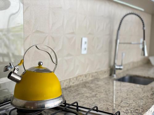 a yellow tea kettle sitting on a stove in a kitchen at Apartamento dos Sonhos - Centro BC in Balneário Camboriú