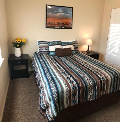 a bedroom with a large bed and a vase of flowers at Cedar Canyon Condos in Blanding