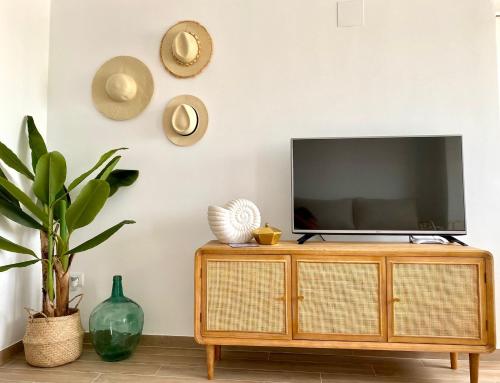 TV en la parte superior de un armario de madera en la sala de estar. en Apartamento En calma, en Peñíscola