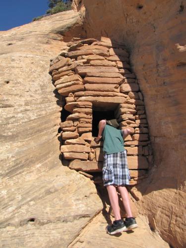 a man is looking out of a rock oven at Cedar Canyon Condos in Blanding