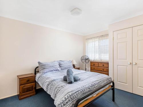 ein Schlafzimmer mit einem Bett, auf dem ein Stofftier liegt in der Unterkunft Home away from home in Gerringong