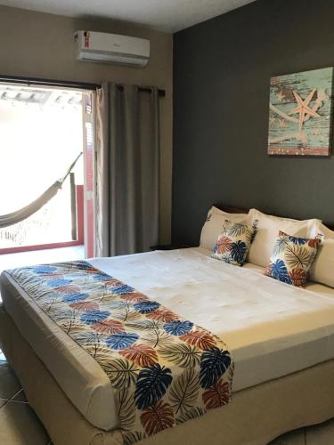 ein großes Bett in einem Schlafzimmer mit Fenster in der Unterkunft Pousada Vista Dell Mar in Ubatuba