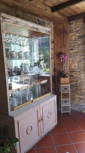 a cabinet with a glass window in a room at A Casa das Augas in Mondoñedo
