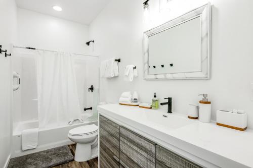 a white bathroom with a toilet and a sink at The Villas 12A in Pagosa Springs