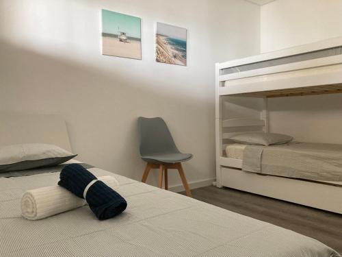 a bedroom with two beds and a bunk bed and a chair at Sesimbra by the sea in Sesimbra