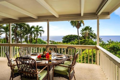 a table on a balcony with a view of the ocean at Kona Sunset House at Walua in Kailua-Kona