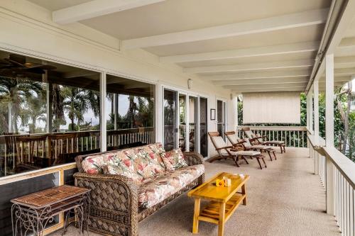 a porch with a couch and a table at Kona Sunset House at Walua in Kailua-Kona