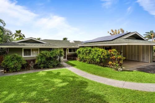 a house with a green yard at Kona Sunset House at Walua in Kailua-Kona