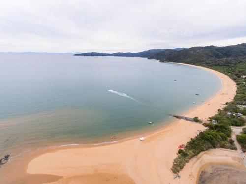 an aerial view of a beach with a boat in the water at Century Park in Nelson