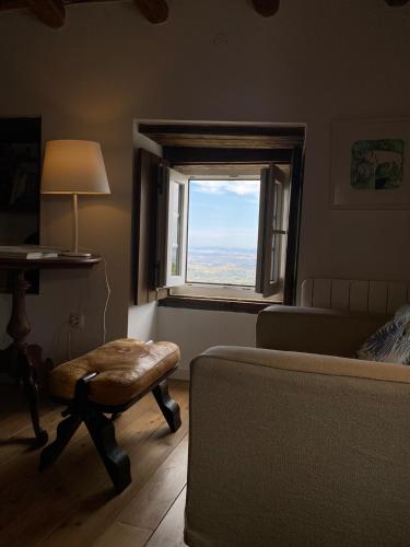 a living room with a chair and a window at Casa do Sétimo Passo in Marvão