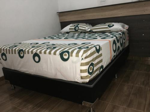 1 cama con edredón y almohadas en blanco y negro en HOTEL LA CASONA en Buga