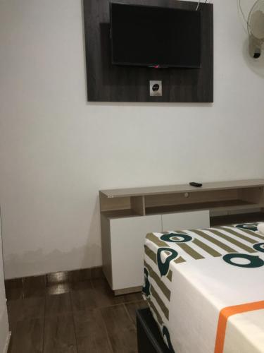 a room with a tv on the wall and a bed at HOTEL LA CASONA in Buga