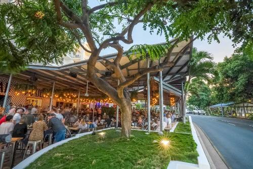 an outdoor restaurant with people sitting at tables at Airlie Beach Hotel in Airlie Beach