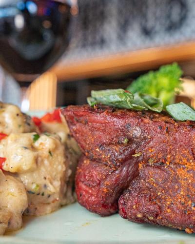 a plate of food with meat and broccoli on it at Airlie Beach Hotel in Airlie Beach