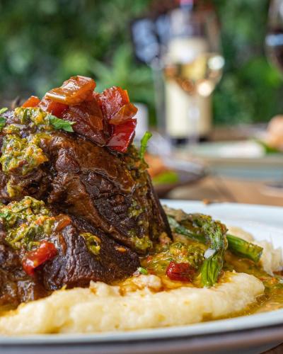 a plate of food with meat and vegetables on a table at Airlie Beach Hotel in Airlie Beach