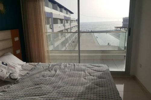 um quarto com uma cama e vista para a praia em Appartement familial luxueux pieds dans l'eau em Aourir