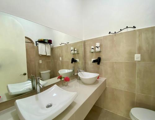 a bathroom with a sink and two toilets at The Quetzal in Cancún