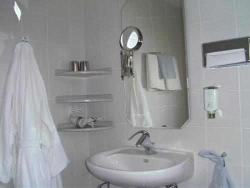 a white bathroom with a sink and a mirror at Hotel Ambiente in Hof