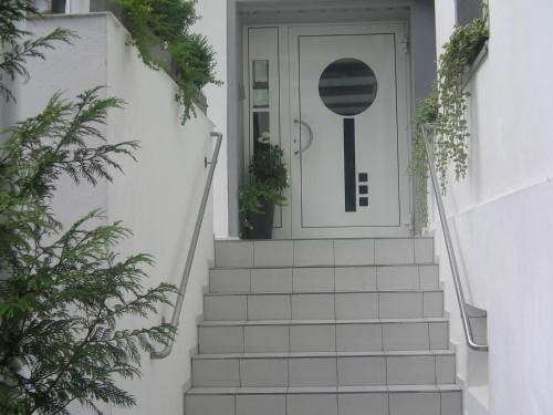 a stairway leading to a white door with plants at Hotel Ambiente in Hof