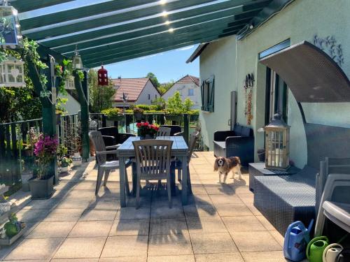 a patio with a table and a dog walking on it at le nid fleuri de Cravanche in Cravanche