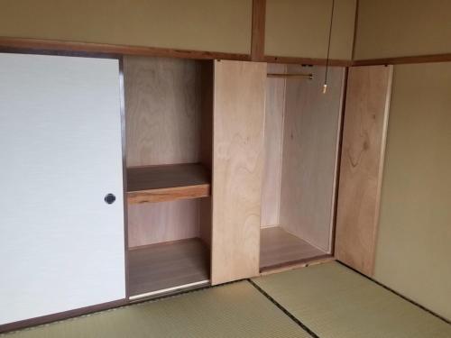 a closet with a door in a room at コンドミニアム海のまんまえ荘 in Ōda