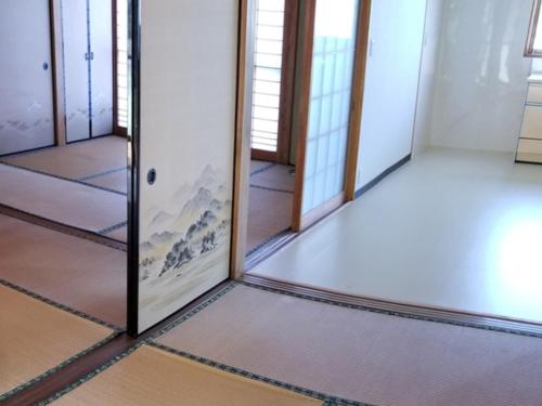 a room with four doors and a mirror at コンドミニアム海のまんまえ荘 in Kangoji