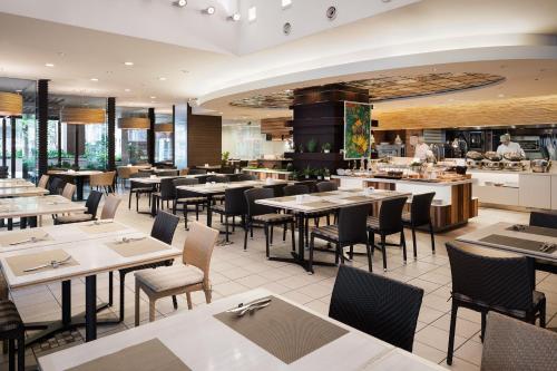 a restaurant with tables and chairs and a bar at ANA Crowne Plaza Fukuoka by IHG in Fukuoka