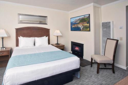 a hotel room with a bed and a fireplace at Villa Franca Inn in Monterey