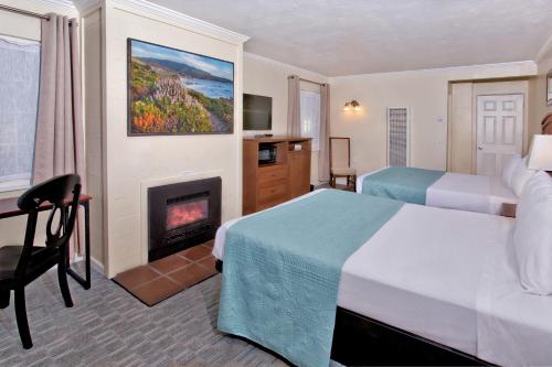 a hotel room with a bed and a fireplace at Villa Franca Inn in Monterey