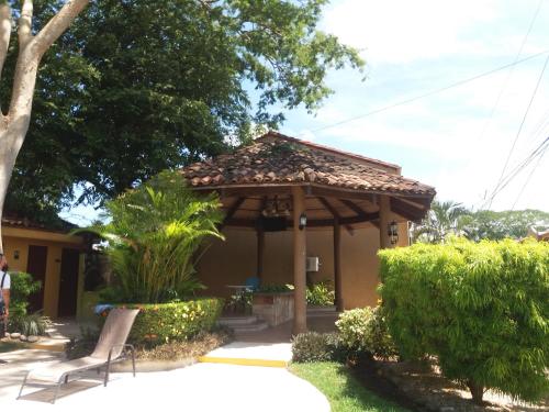 a gazebo with a bench in a yard at Villa Prados del Rio - Guanacaste, Costa Rica in Comunidad