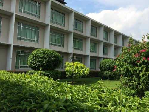 an apartment building with bushes in front of it at Straits View Hotel JB in Johor Bahru