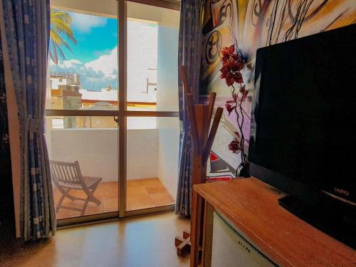 a living room with a television and a balcony at 17 Happiness in Xiaoliuqiu