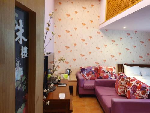 a living room with a purple couch and a bed at 17 Happiness in Xiaoliuqiu