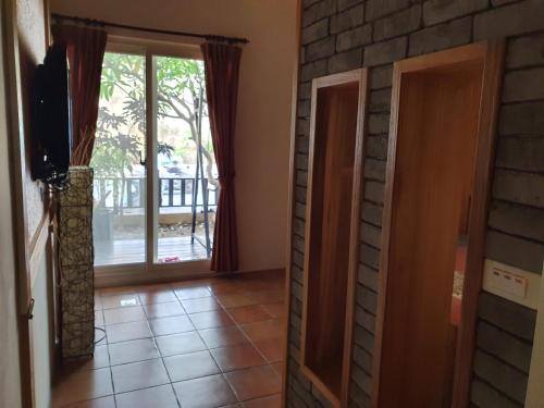 a living room with a door leading to a balcony at 17 Happiness in Xiaoliuqiu