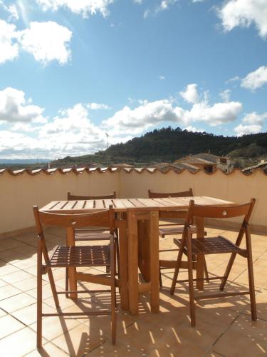 a wooden table and two chairs on a patio at Apartamentos Maribel in Calaceite